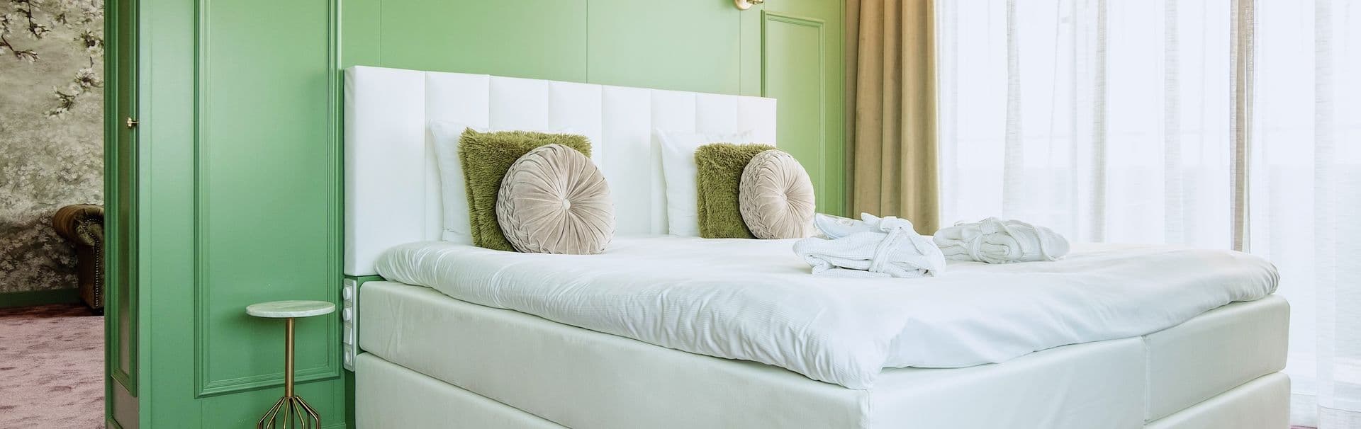 Sierkussens op een hotelbed met wit headboard